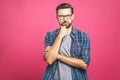 Portrait of unhappy determined european male with bristle touching chin while thinking and looking with serious and worried look