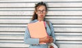 Portrait of an unhappy female student carrying lots of books after a day in the college. Pretty sad young woman wearing a blue Royalty Free Stock Photo