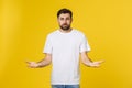 Portrait unhappy handsome man looking at camera on yellow background.