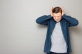 Portrait of unhappy mature man covering ears with hands