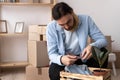 Portrait of unhappy modern man in t-shirt near cardboard box with a broken dish on home background Royalty Free Stock Photo