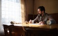 Portrait of unhappy poor mature man reading newspapers indoors at home, poverty concept. Royalty Free Stock Photo