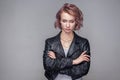 Portrait of unhappy sad beautiful girl with short hairstyle and makeup in casual style black leather jacket standing closed eyes