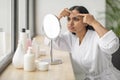 Portrait of upset beautiful young indian woman looking at mirror Royalty Free Stock Photo