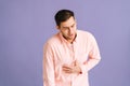 Portrait of unhappy young man feeling sudden stomach pain, severe abdominal distress, suffering nausea going to throw up Royalty Free Stock Photo