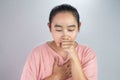 Portrait of unhealthy Asian young woman suffering with cough and  has a chest pain on grey background Royalty Free Stock Photo