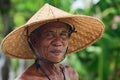 Portrait of an unidentified old Balinese farmer with a wrinkled face in traditional straw wide-brimmed hat