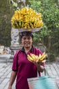 Portrait of an unidentified woman together with bananas on her head on the market by the water temple in Bali, Indonesia Royalty Free Stock Photo