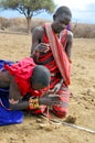 Portrait of unidentified young Maasai warriors shows how to make fire Royalty Free Stock Photo