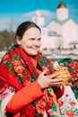 Portrait of unknown beautiful young woman girl with headscarf on her shoulders and pot in her hands at Celebration of