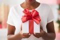 Portrait unrecognizable young African American female woman lady holding giving gift box present red bow blurred Black