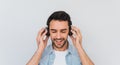 Portrait of unshaven handsome young Caucasian male with cheerful expression, closes eyes as feels enjoyment and happiness, holding Royalty Free Stock Photo