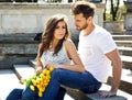 Portrait of unusual couple with yellow tulips sitting and resting