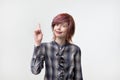 Portrait of unusual informal pretty woman with colorful hairstyle pointing with finger up.