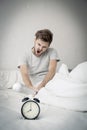 Portrait upset angry with baseball hit young man screaming at alarm clock on bedroom. Royalty Free Stock Photo