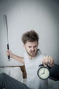 Portrait upset angry with baseball hit young man screaming at alarm clock on bedroom. Royalty Free Stock Photo