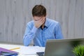 Portrait of an upset businessman at desk in office. Businessman being depressed by working in office