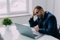 Portrait of an upset businessman at desk in office. Businessman being depressed by working in office Royalty Free Stock Photo