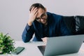 Portrait of an upset businessman at desk in office. Businessman being depressed by working in office Royalty Free Stock Photo