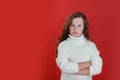 Portrait of upset casual girl standing with arms folded over red background Royalty Free Stock Photo