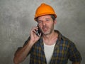 Portrait of upset construction worker or stressed contractor man in builder hat talking on mobile phone unhappy in stress messing Royalty Free Stock Photo