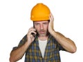 Portrait of upset construction worker or stressed contractor man in builder hat talking on mobile phone unhappy in stress messing Royalty Free Stock Photo