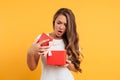 Portrait of an upset disappointed girl opening gift box Royalty Free Stock Photo