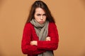 Portrait of upset freezing woman in red knitted sweater standing