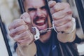 Portrait of upset handcuffed man imprisoned for crime, punished for serious villainy. Arrest, gangster, pain concept. Selective Royalty Free Stock Photo