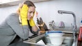 Portrait of upset young housewife looking at stack of dishes Royalty Free Stock Photo