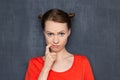 Portrait of upset puzzled young woman holding finger in mouth Royalty Free Stock Photo