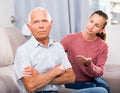 Portrait of upset senior man and daughter quarrelling at home