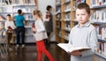 Upset tween boy browsing book Royalty Free Stock Photo