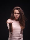 Sad woman holding tangled hair on the black background. Tuft of hair on a girl`s hand. Hair loss concept. Copy space. Royalty Free Stock Photo