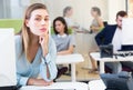 Upset young female foreground in busy open plan office indoor Royalty Free Stock Photo