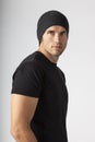 Portrait of urban young man wearing black t-shirt and knit hat. Men`s modern casual clothing fashions street styles.