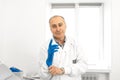 Portrait of a urologist doctor putting on medical gloves before examining a patient