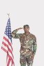 Portrait of US Marine Corps soldier saluting American flag over gray background Royalty Free Stock Photo