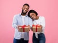 Portrait of Valentine sweethearts with gift boxes celebrating holiday together on pink studio background Royalty Free Stock Photo