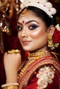 Portrait of very beautiful young Indian bride in luxurious bridal costume with makeup and heavy jewellery . Royalty Free Stock Photo