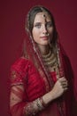 Portrait of very beautiful young Indian bride in luxurious bridal costume with makeup and heavy jewellery Royalty Free Stock Photo