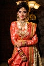 Portrait of very beautiful young Indian bride in luxurious bridal costume with makeup and heavy jewellery in studio lighting Royalty Free Stock Photo