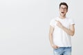 Portrait of very happy charming and attractive young man in glasses holding breath from excitement and amazement smiling