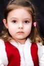 Portrait of very serious baby girl in red santa dress Royalty Free Stock Photo