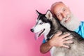 Portrait of veterinarian advertise high quality care for pets hug siberian husky isolated on pastel color background