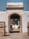 Portrait view of a city wall and gate. One family walking inside gates.