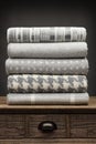 Portrait view of 5 grey luxury folded throws shot on a wooden sideboard, with a grey background Royalty Free Stock Photo