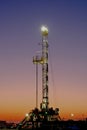 Portrait view of an oil drilling rig at sunrise. Royalty Free Stock Photo