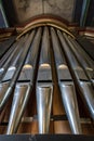 Portrait view of a rank of shining steel pipes of a refurbished church organ