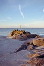 Portrait view with rocks and sandy beach in foreground of Morris Island Lighthouse Royalty Free Stock Photo